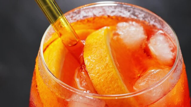 Aperol Spritz cocktail, close up. Cocktail Aperol Spritz with oranges and ice cubes in glass. Traditional italian aperitif cocktail. Handheld shot