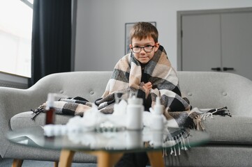 Fototapeta premium little child boy is sick. A thick scarf is wrapped around her neck. Treatment of colds and flu. sick child boy.
