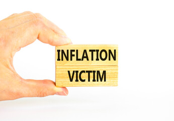 Inflation victim symbol. Concept words Inflation victim on wooden block. Beautiful white table white background. Businessman hand. Business inflation victim concept. Copy space.
