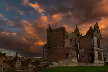 Obraz premium Abandoned old mansion house in ruins. Dramatic sunset with rain clouds building in the background