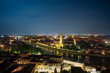 Famous old town of Verona at night. Colorful city lights reflecting in the river Adige. Long exposure.