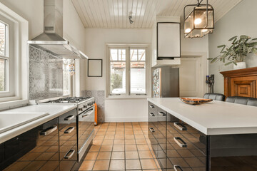 a kitchen with black and white tiles on the floor, along with an island in the center of the room