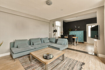 a living room with a couch and coffee table in the middle of the room, there is a large mirror on the wall