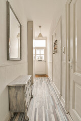 a hallway with wood flooring and white painted walls in the background is a mirror on the wall...