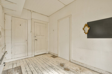 an empty room with white walls and wood floorboards on the wall, there is a black chalk board hanging on the wall