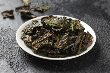 Fototapeta na wymiar A delicious Kale chips, snack on white plate. Healthy vegetable food.