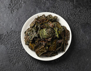 A delicious Kale chips, snack on white plate. Healthy vegetable food.
