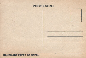 Hand craft nepal paper postcard background. Homemade brown patchy blank page with pieces of grass, newspapers, fibers, secondary raw materials, waste processing.