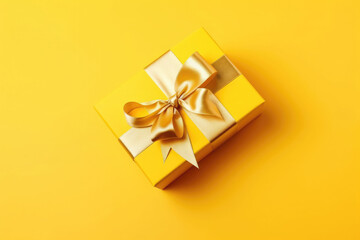 Obraz na płótnie Canvas Gift box with golden satin ribbon and bow on yellow background. Generative AI