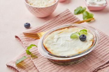 Delicious cottage cheese casserole in portioned glass forms with sour cream. Traditional Russian cuisine for breakfast - Zapekanka.