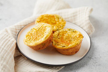 Savory muffins with egg, feta cheese, cheddar and spinach on light background