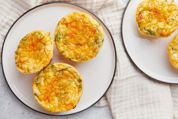 Savory muffins with egg, feta cheese, cheddar and spinach on light background