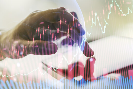 Multi exposure of abstract financial graph with world map and hand working with a digital tablet on background, financial and trading concept