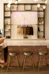 THE WOODLANDS, TEXAS - MAY 5TH 2023:  a female manager of The Beauty Lounge salon is posing for a business portrait in the salon against her company logo. She holds a professional hair extension set