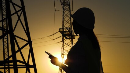 silhouette of an electrical engineer. engineer work tablet sunset. studying electrical technology...
