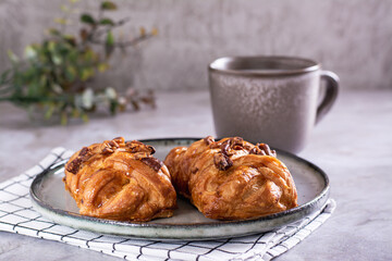 Wicker buns with cinnamon, nuts and maple syrup and a cup of coffee for Swedish fika time