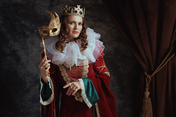 medieval queen in red dress with venetian mask