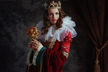 medieval queen in red dress with dried flower and white collar