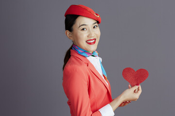 smiling stylish asian female air hostess against gray
