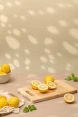 Whole and halves of yellow lemons on a wooden board. Juicy ripe lemons. Copy space