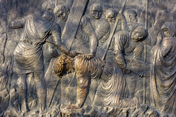 Station III of the Way of the Cross: Jesus falls for the first time. Bronze relief hillside...