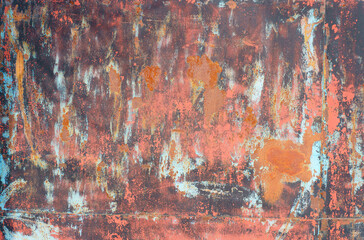 Texture of an old rusty metal sheet with red and gray paint elements.