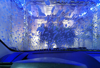Car Care Business. Automatic Car Wash Process. Spray foam bubble shampoo on the car surface. Inside view
