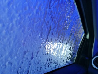 Car Care Business. Automatic Car Wash Process. Spray foam bubble shampoo on the car surface. Inside view, copy space