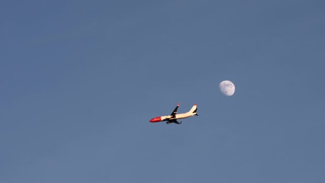 Passenger airplane in the sky on the background, Plane silhouette against a full moon in the sky, airplane flying by the moon, Plane against full moon in the blue sky, airplane flying by the moon