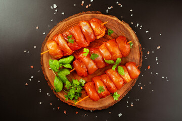 Fresh raw marinated skinless chicken leg meat skewers with fresh herbs on a black background.Top view.Copy space.Marinated Fresh.Closeup of chicken meat.Procurement for designers.