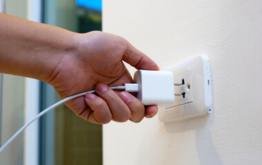 Hand insert a plug of the phone charger into socket.