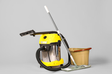 Vacuum cleaner with mop and bucket on grey background © Pixel-Shot
