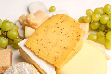 Different types of tasty cheese on light background, closeup