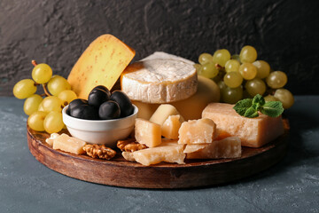 Plate with different types of tasty cheese on table