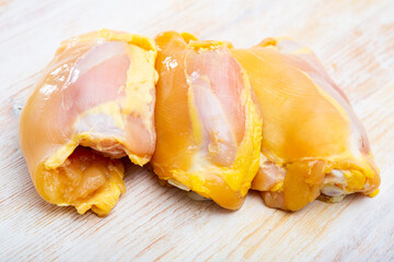 Raw skinless chicken thighs on cutting board. High quality photo