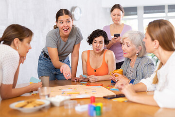 Women spend time over cup of coffee and playing logical board game. concept of development, mental activity in playful way