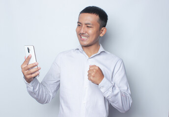 Portrait young Asian man handsome happy smile in formal shirt using smartphone trading or chatting on white isolated studio background.