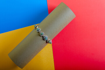Bracelet with emerald stones on a multi-colored background