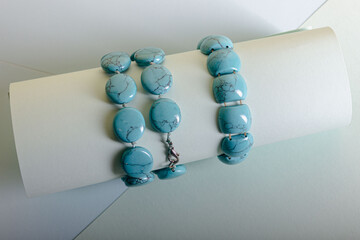 Beads and a bracelet of turquoise color on a light background