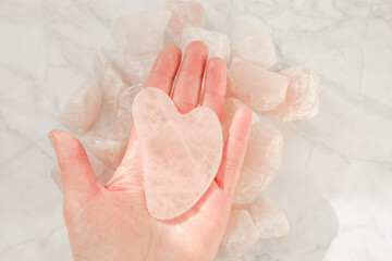 gua sha. Rose quartz massage scraper in the shape of a heart from natural stone .facial massage device.gua sha scraper.