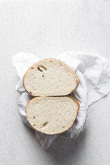 Cross-section of artisan bread cut into half, top view of sesame coated bread cross-section, sandwich bread on a linen napkin