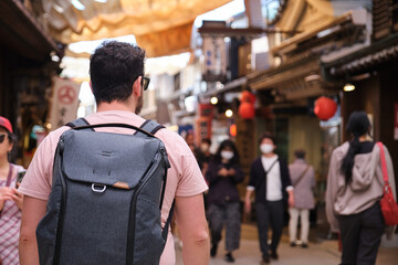 European tourist visiting a traditional japanese street in Miyajima, Hiroshima, Japan.