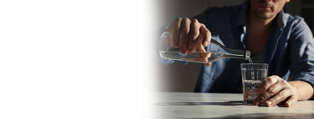 Suffering from hangover. Man pouring alcoholic drink into glass at table indoors, closeup. Banner design with space for text