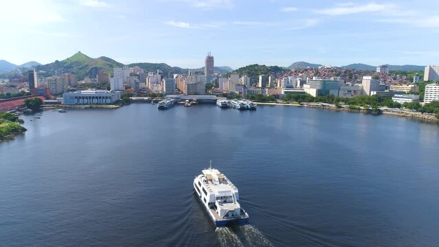 RIO DE JANEIRO, BRASIL - MAY, 2023: Drone aerial view of of Guanabara Bay, the ship is passing by. Modern and historical buildings on the shore in downtown on background at sunny day from above.