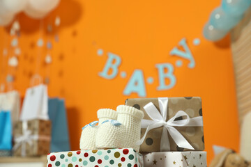Baby shower party. Festive decor, gift boxes and booties in stylish room, space for text