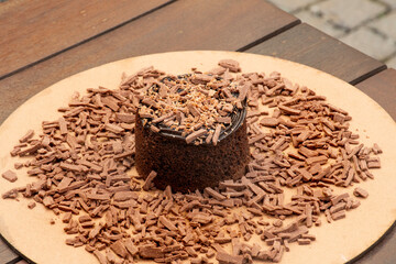 chocolate cake with chocolate shavings and chocolate cream on a rustic bistro table outside