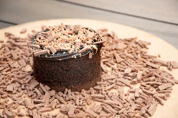 chocolate cake with chocolate shavings and chocolate cream on a rustic bistro table outside close-up