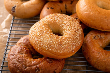 Variety of freshly baked bagels on a cooling rack