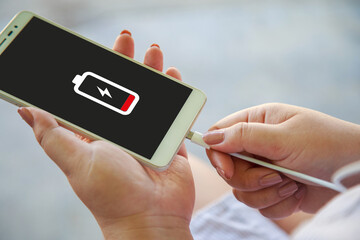 Close up a woman hands charging her smart phone with charging icon