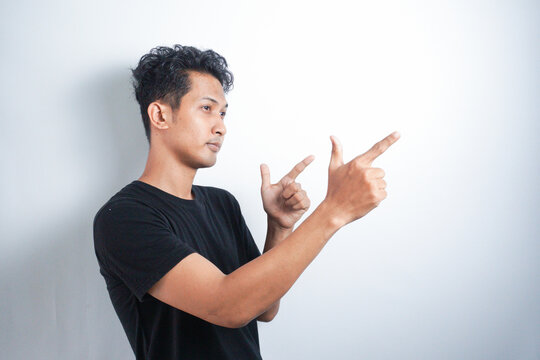Strange asian man makes a gesture with hands like it a gun. White background.